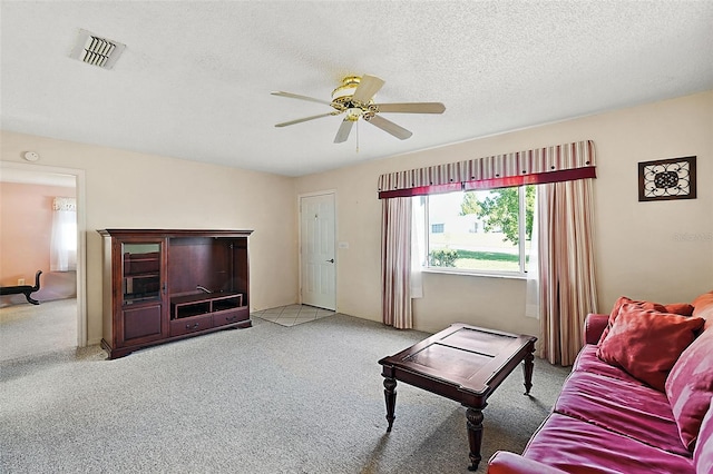 living room featuring a textured ceiling, light colored carpet, and ceiling fan