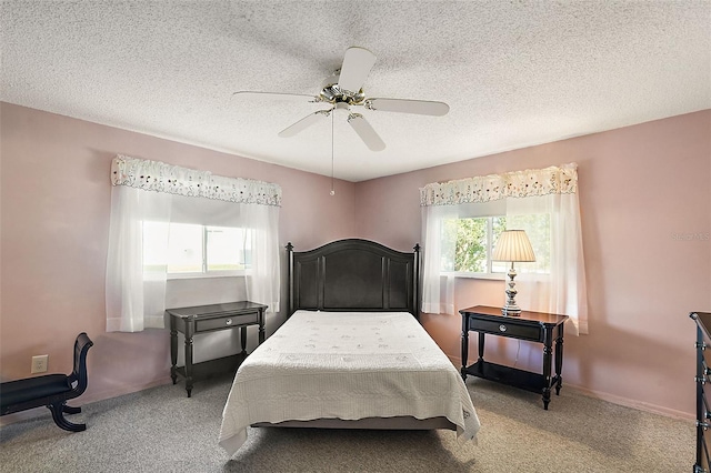 carpeted bedroom with multiple windows, a textured ceiling, and ceiling fan