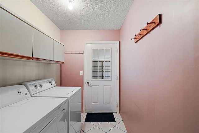 washroom featuring light tile patterned floors, a textured ceiling, cabinets, and separate washer and dryer