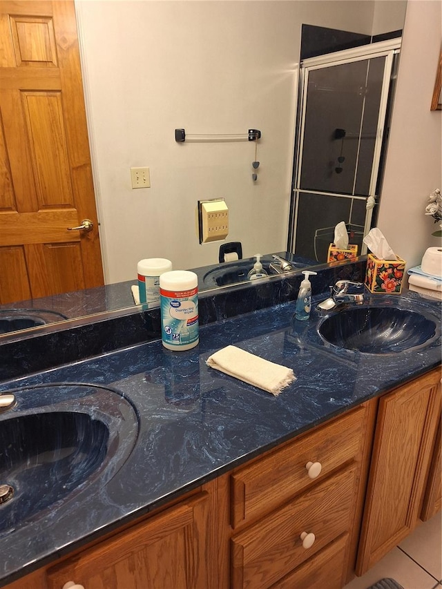 bathroom with vanity, tile patterned floors, and a shower with door