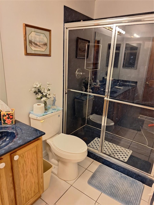 bathroom featuring vanity, tile patterned floors, toilet, and walk in shower