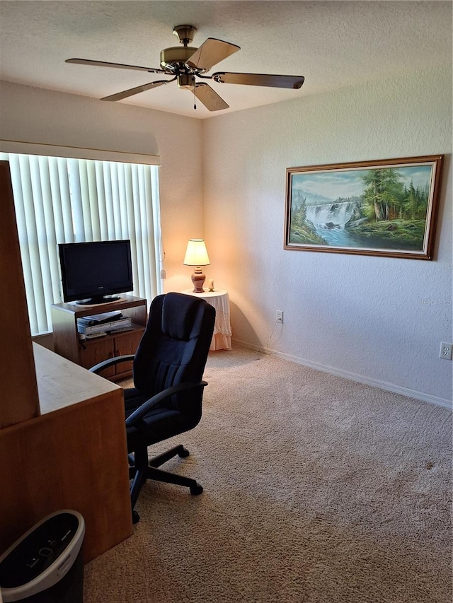 carpeted office space featuring ceiling fan