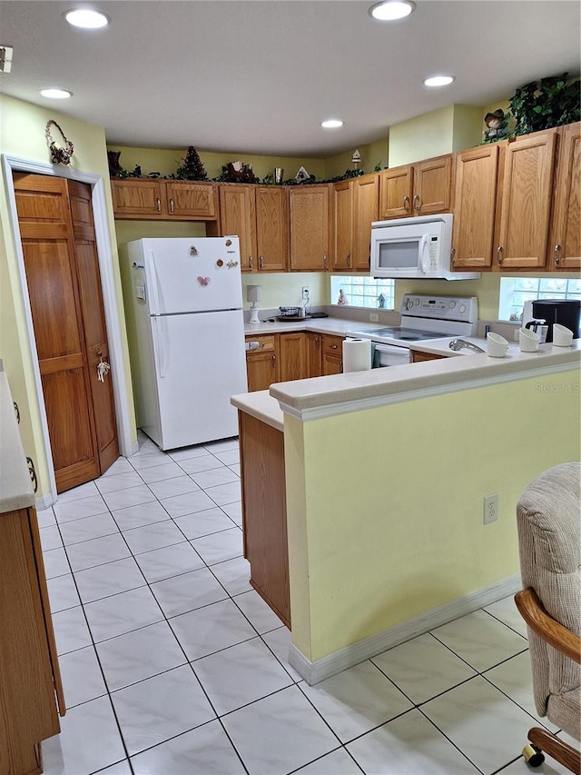 kitchen featuring kitchen peninsula, white appliances, and light tile patterned floors