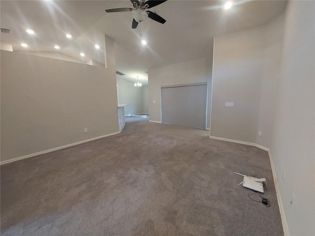 empty room with ceiling fan with notable chandelier, carpet floors, and vaulted ceiling