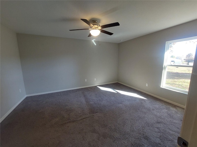 carpeted empty room with a wealth of natural light and ceiling fan