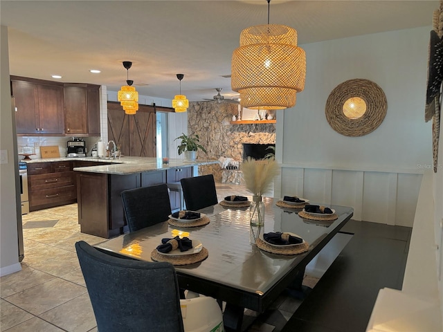 dining space featuring ceiling fan, a barn door, and sink