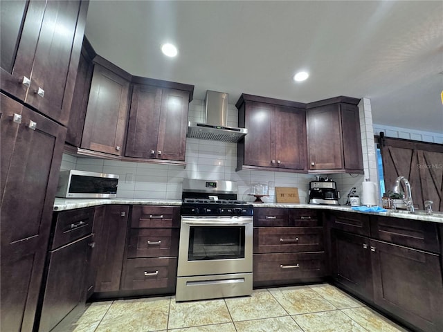 kitchen with stainless steel appliances, backsplash, light stone counters, and wall chimney exhaust hood