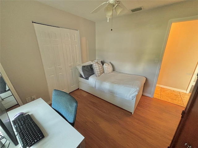 bedroom with hardwood / wood-style flooring, a closet, and ceiling fan