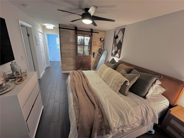 bedroom featuring a barn door and ceiling fan