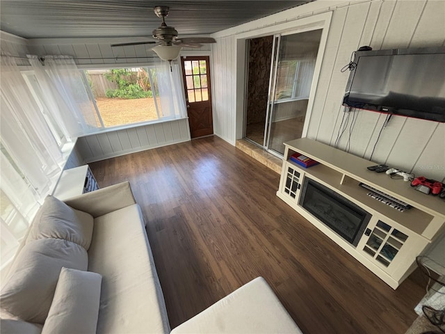 living room with ceiling fan and dark hardwood / wood-style flooring