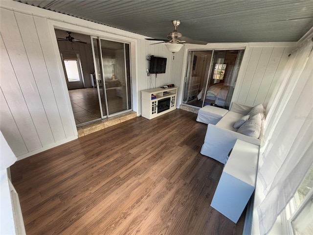 living room featuring a wealth of natural light, dark wood-type flooring, and ceiling fan