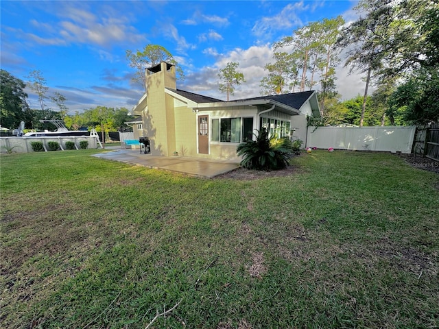 rear view of house with a lawn and a patio area