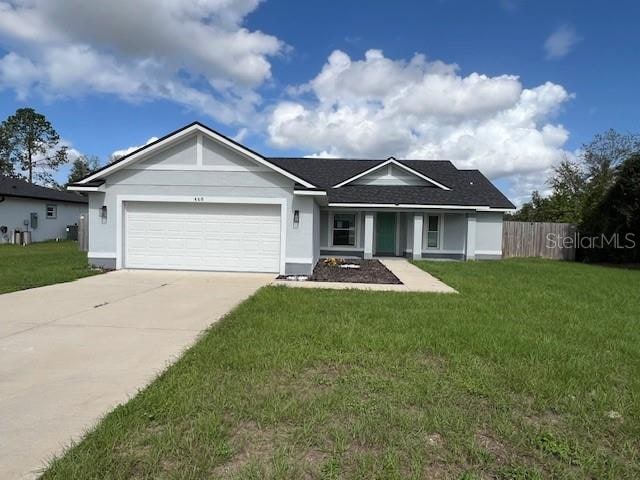 ranch-style house featuring a garage and a front lawn