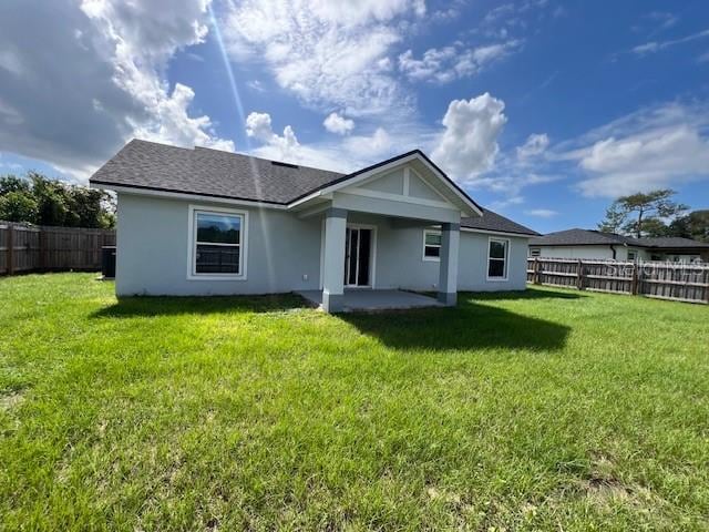 back of property with a patio area and a lawn