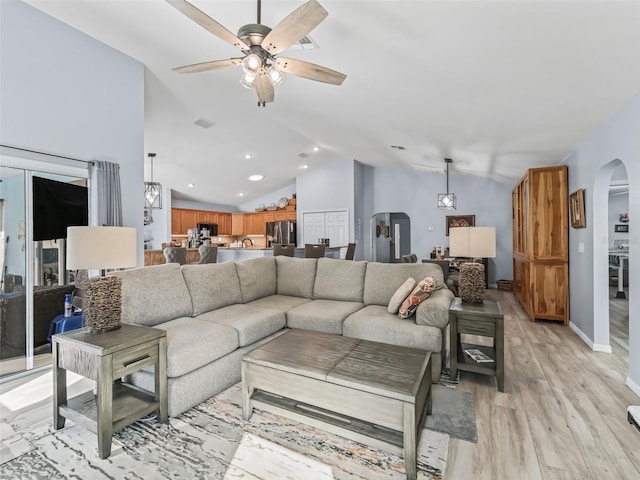 living room featuring ceiling fan, lofted ceiling, and light hardwood / wood-style floors