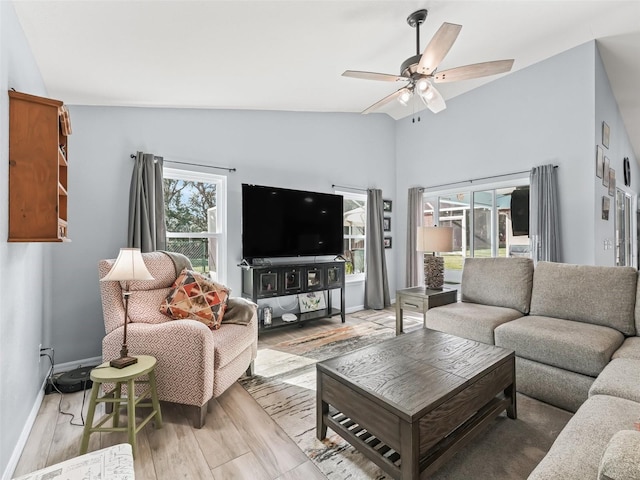 living room featuring light hardwood / wood-style flooring, high vaulted ceiling, and ceiling fan