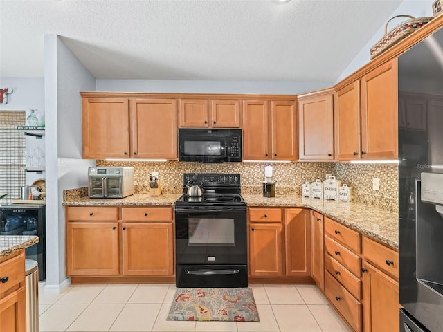 kitchen featuring light tile patterned floors, tasteful backsplash, and black appliances