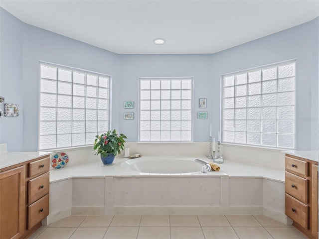 bathroom with vanity, a wealth of natural light, a bathtub, and tile patterned floors