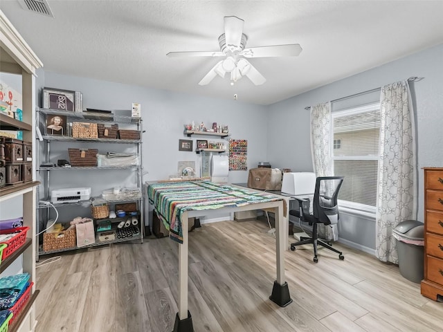 bedroom with light hardwood / wood-style flooring, ceiling fan, and a textured ceiling