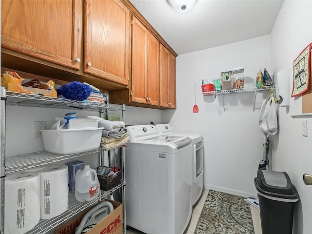 laundry room featuring cabinets, light tile patterned floors, and washing machine and dryer