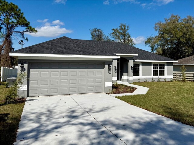 single story home featuring a front yard, roof with shingles, an attached garage, and stucco siding