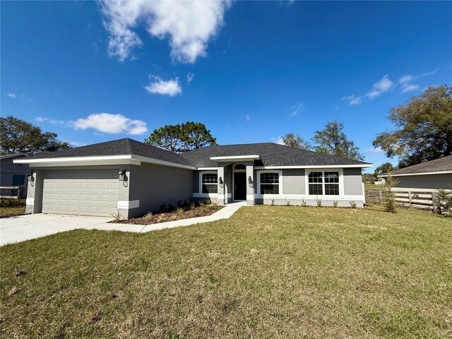 ranch-style house featuring concrete driveway, an attached garage, fence, a front yard, and stucco siding