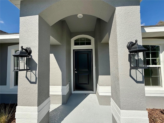 entrance to property with stucco siding