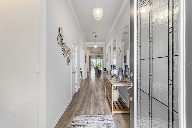 hallway with hardwood / wood-style floors and crown molding