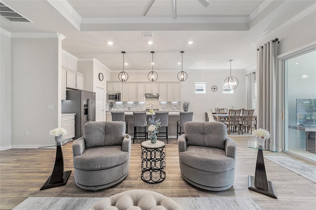 living room with a textured ceiling, light hardwood / wood-style flooring, and crown molding