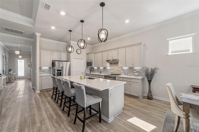 kitchen with appliances with stainless steel finishes, light hardwood / wood-style floors, a healthy amount of sunlight, and crown molding