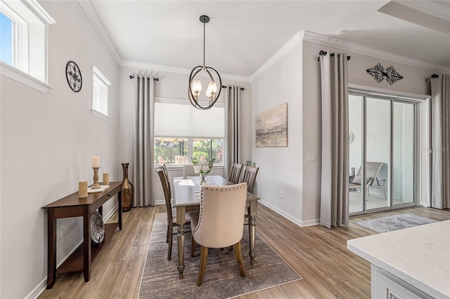 dining space featuring a wealth of natural light, crown molding, and light hardwood / wood-style flooring