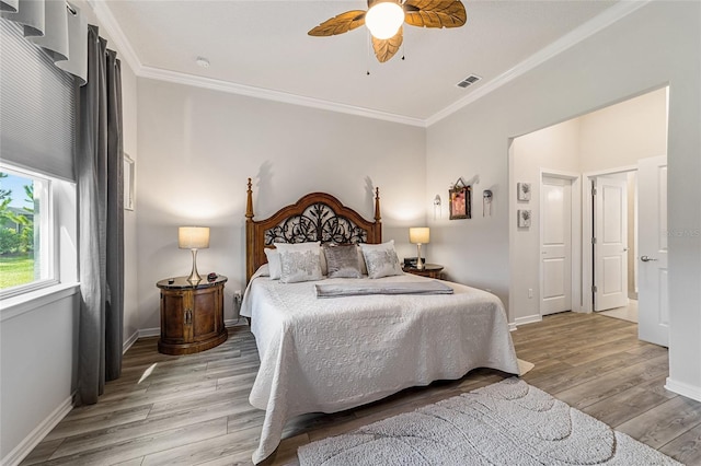 bedroom with ornamental molding, ceiling fan, and light hardwood / wood-style floors