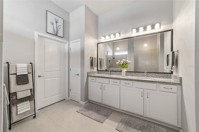 bathroom featuring walk in shower, vanity, tile patterned floors, and a textured ceiling