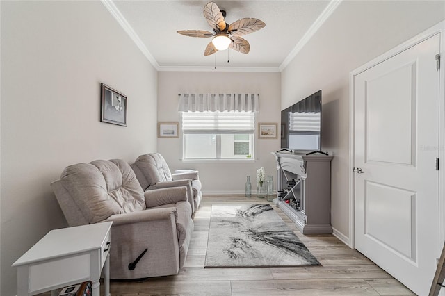 living room with ornamental molding, light hardwood / wood-style floors, and ceiling fan