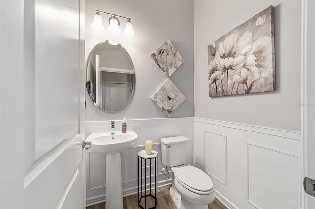 bathroom featuring hardwood / wood-style flooring and toilet