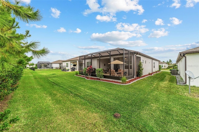 view of yard with central AC unit and a lanai