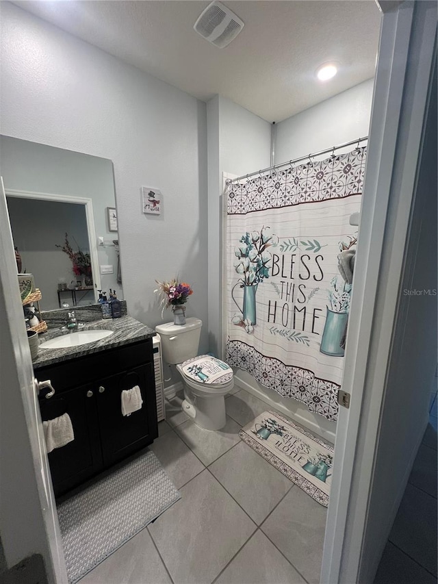 bathroom featuring toilet, vanity, and tile patterned floors