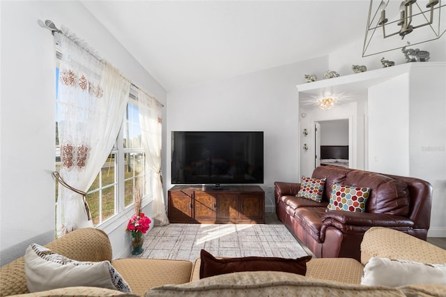 living room featuring plenty of natural light, lofted ceiling, and a chandelier