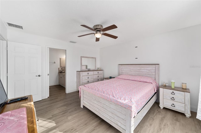 bedroom featuring ceiling fan, light wood-type flooring, and ensuite bathroom