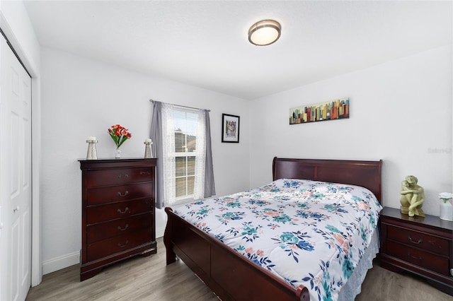 bedroom with light wood-type flooring and a closet