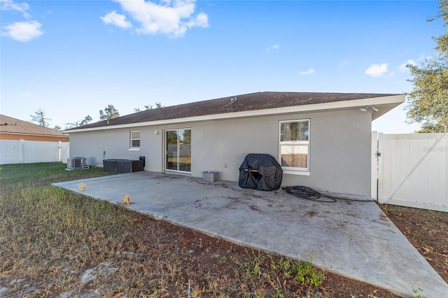 back of property with central air condition unit and a patio