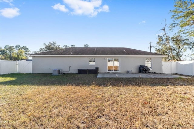 back of house featuring central AC, a yard, and a patio