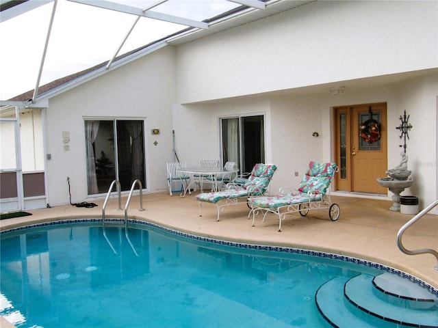 rear view of property with a patio area and glass enclosure