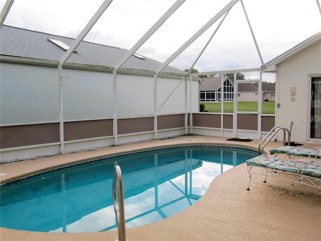 view of swimming pool featuring a patio and glass enclosure