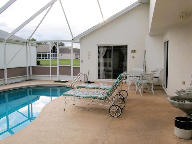 view of swimming pool featuring a patio and glass enclosure