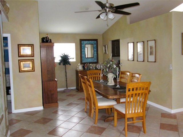 dining room with ceiling fan, vaulted ceiling, and light tile patterned floors