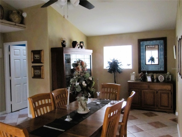 tiled dining space with vaulted ceiling and ceiling fan