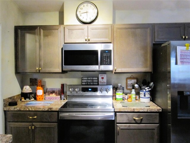 kitchen featuring stainless steel appliances and light stone counters