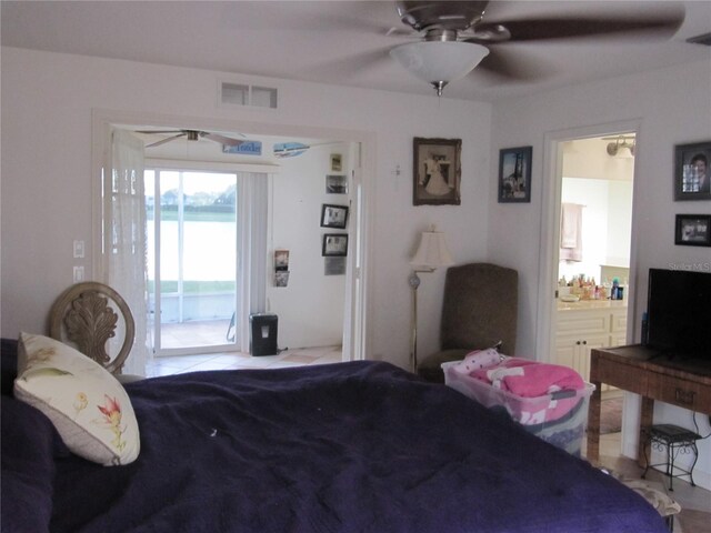 bedroom featuring connected bathroom, a water view, access to outside, and ceiling fan