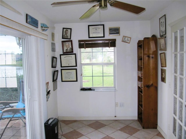 doorway with ceiling fan and light tile patterned floors